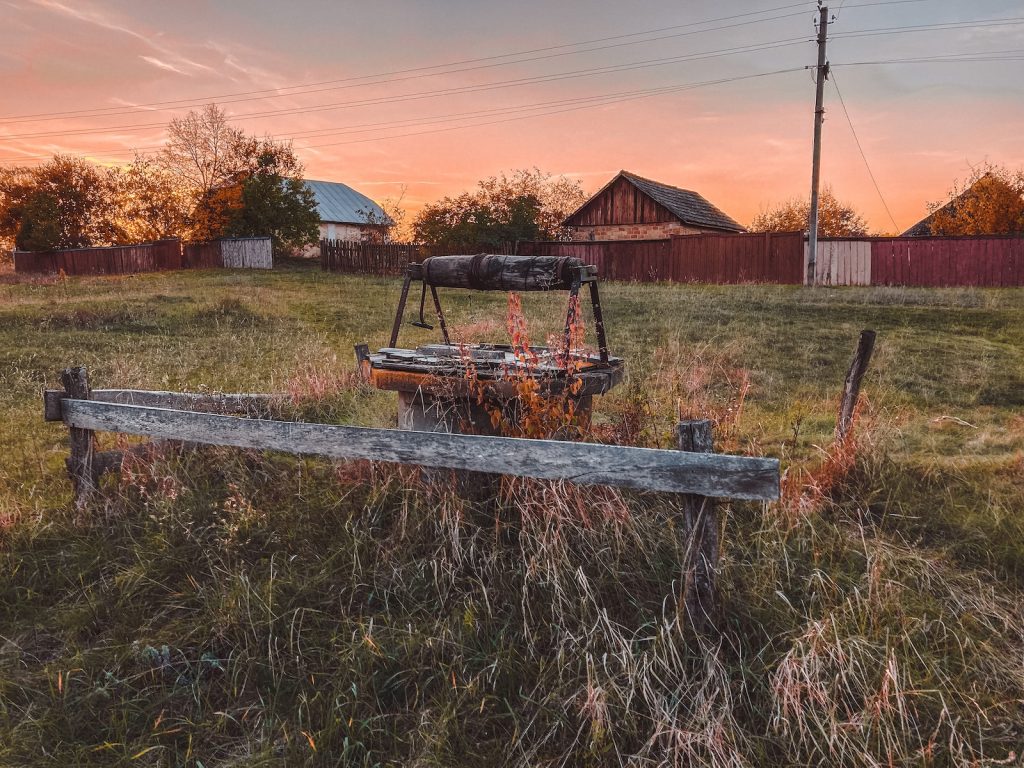 a wooden bench sitting in the middle of a field